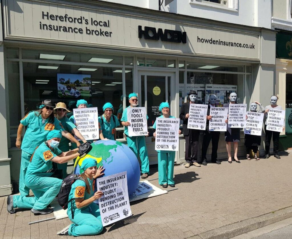 Group wearing suits and masks and group in medical scrubs outside Howdens